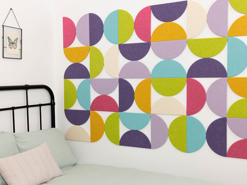 Bedroom with a colorful geometric wall design and black metal bed frame.