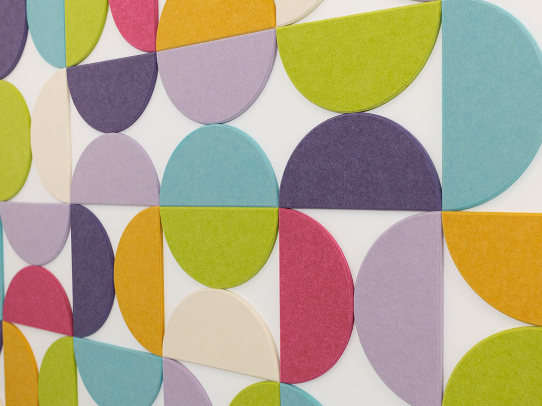 Bedroom with a colorful geometric wall design and black metal bed frame.