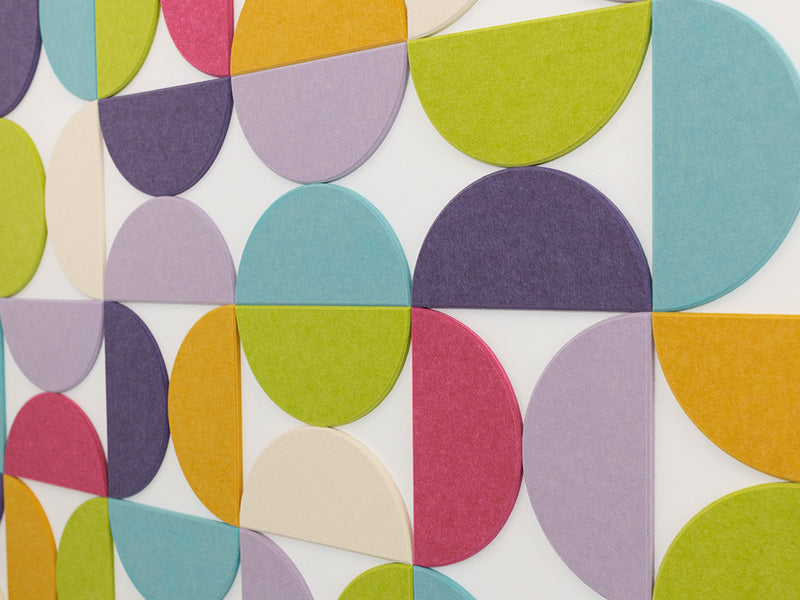 Bedroom with a colorful geometric wall design and black metal bed frame.