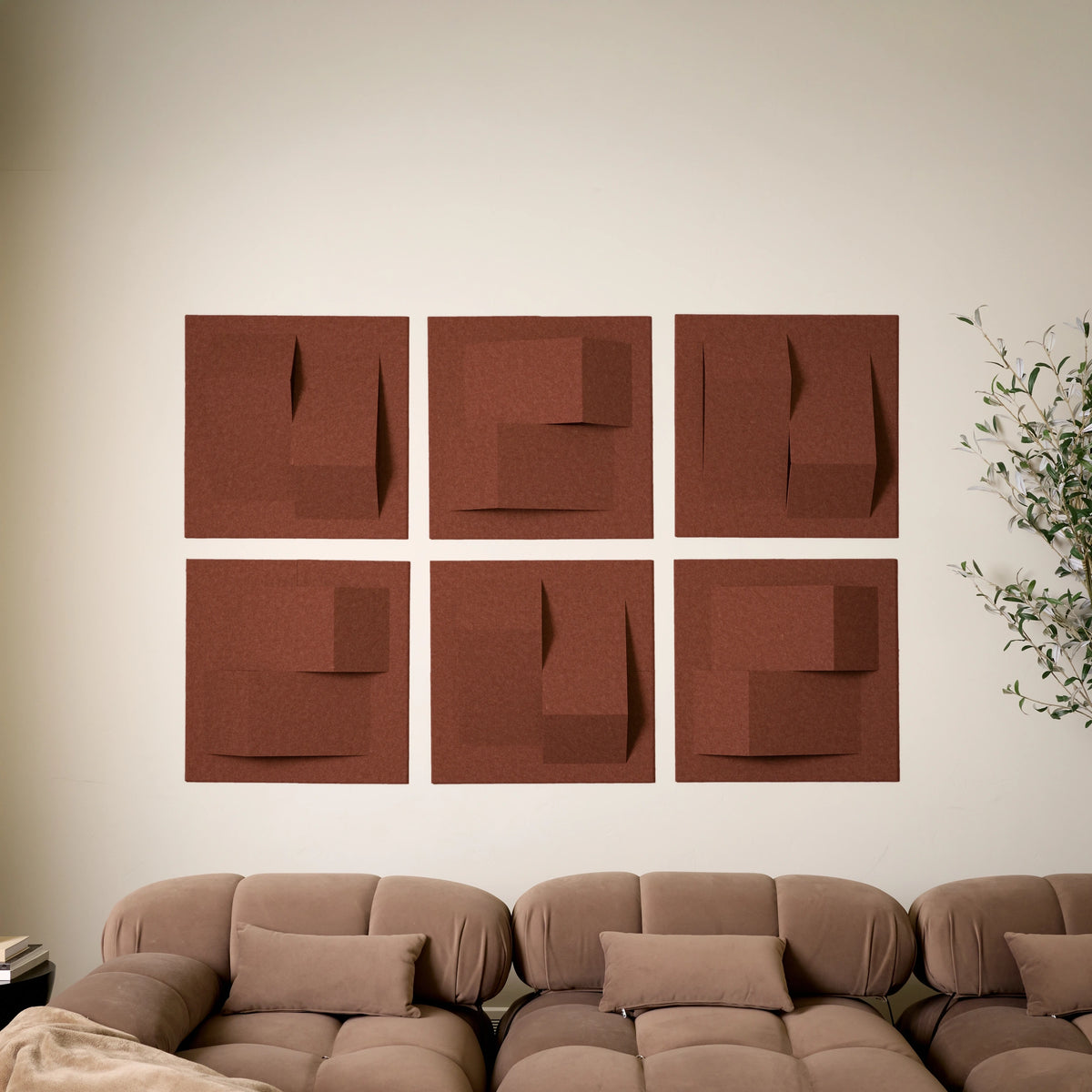 Dark orange acoustic felt wall tiles arranged in a modern geometric design above a sofa