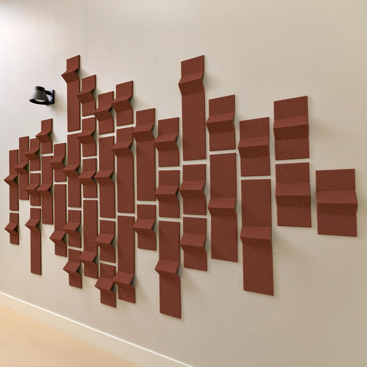 Dark orange acoustic felt tiles on a wall  in a modern geometric design