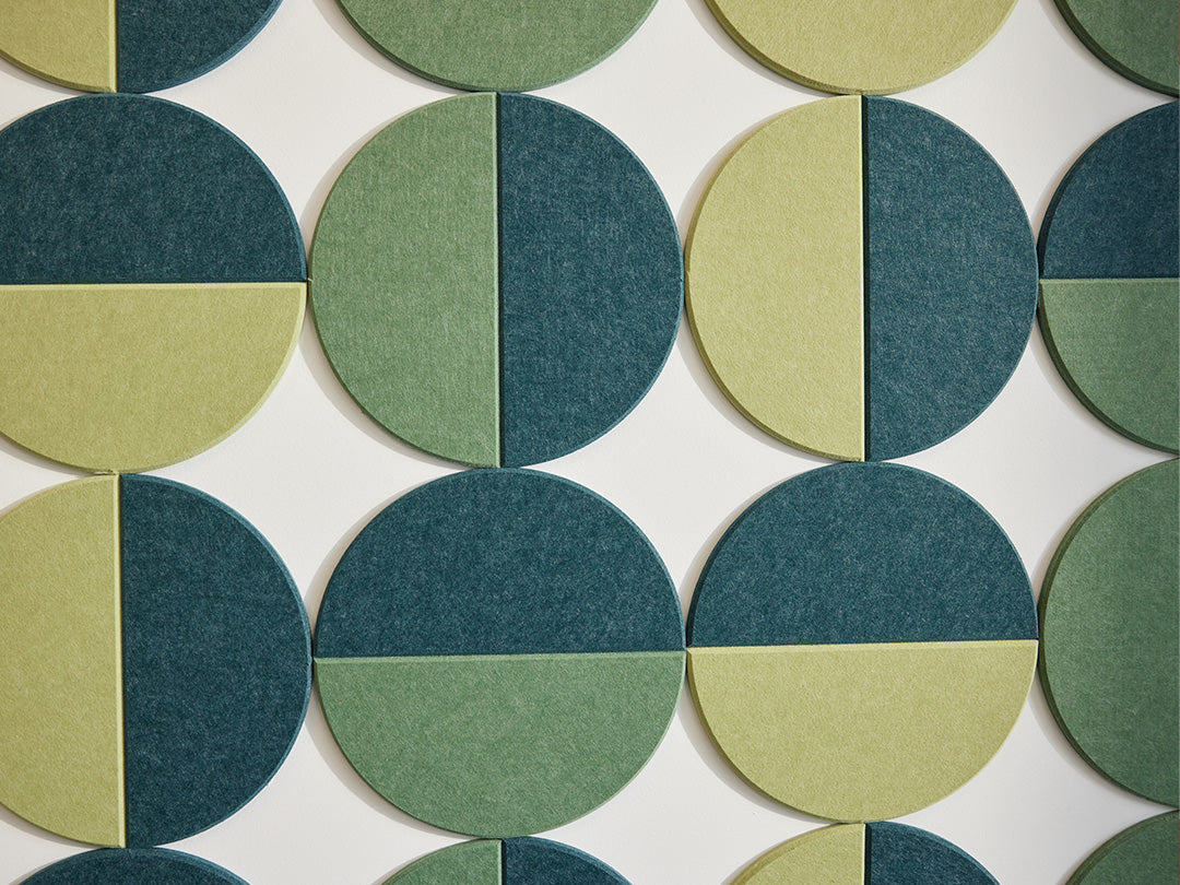 felt right half circle tiles in shades of green creating circles with negative space on a white wall