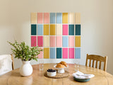 Dining room with a wooden table, chairs, and a colorful wall art above.