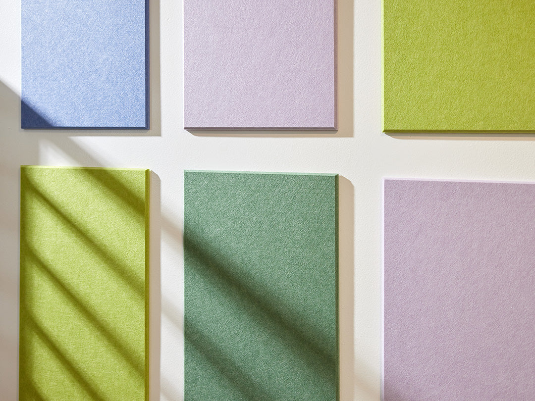 Felt Right wall art in shades of blue, purple, and green felt rectangles on a white wall 