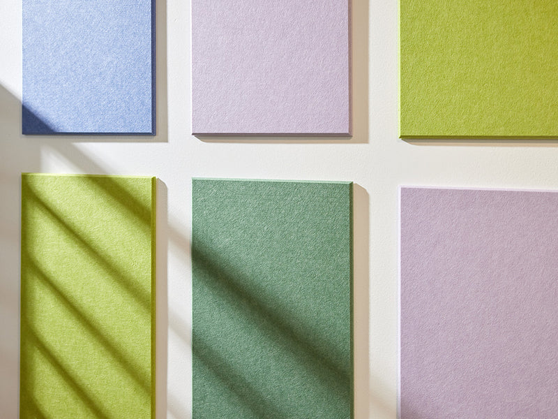 Felt Right wall art in shades of blue, purple, and green felt rectangles on a white wall 