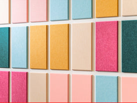 Grid of colorful square tiles on a textured surface