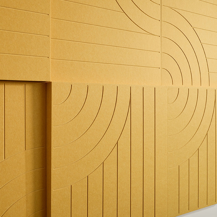 close up shot of yellow acoustic boxes on wall with organic engraving