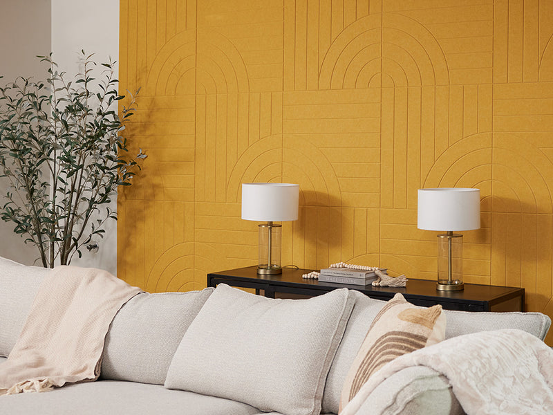 A Felt Right Wall design in a yellow shade in a living room behind a table with two lamps and a couch