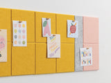 Colorful bulletin board with sticky notes and small posters on a white background