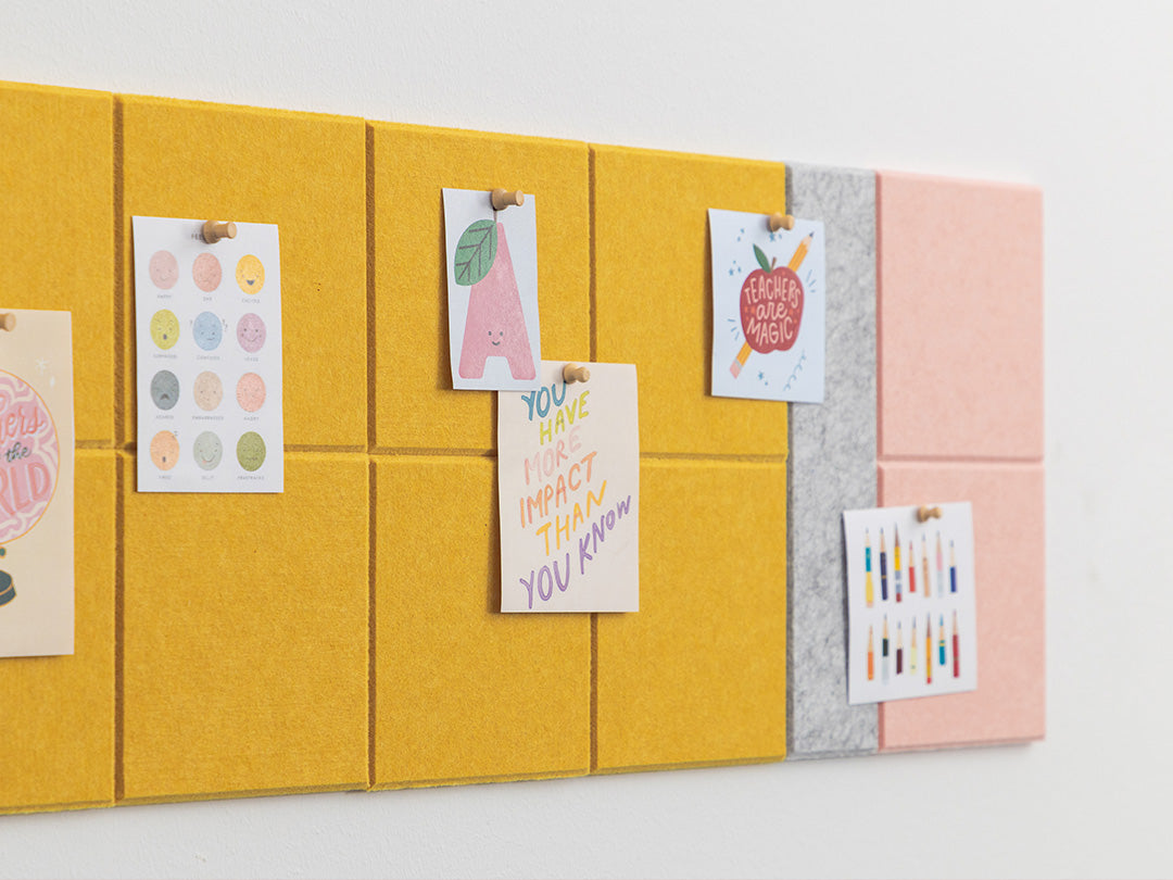 Colorful bulletin board with sticky notes and small posters on a white background