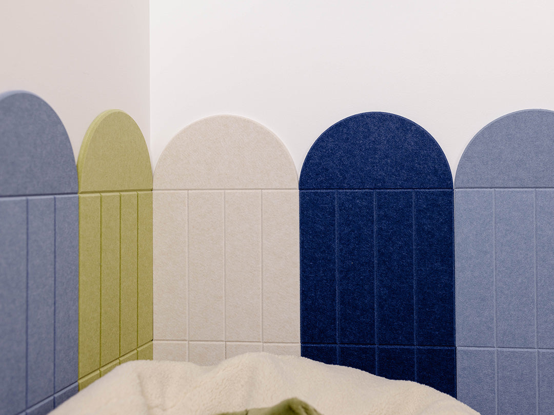 Children's room with a bean bag, plush toys, and colorful wall design.