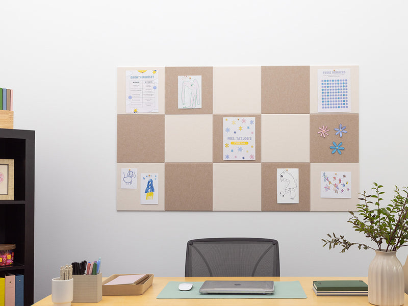 Home office with a cork bulletin board, desk, chair, and decorative items.
