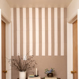 Beige and white striped wall with decorative elements like a plant and books.