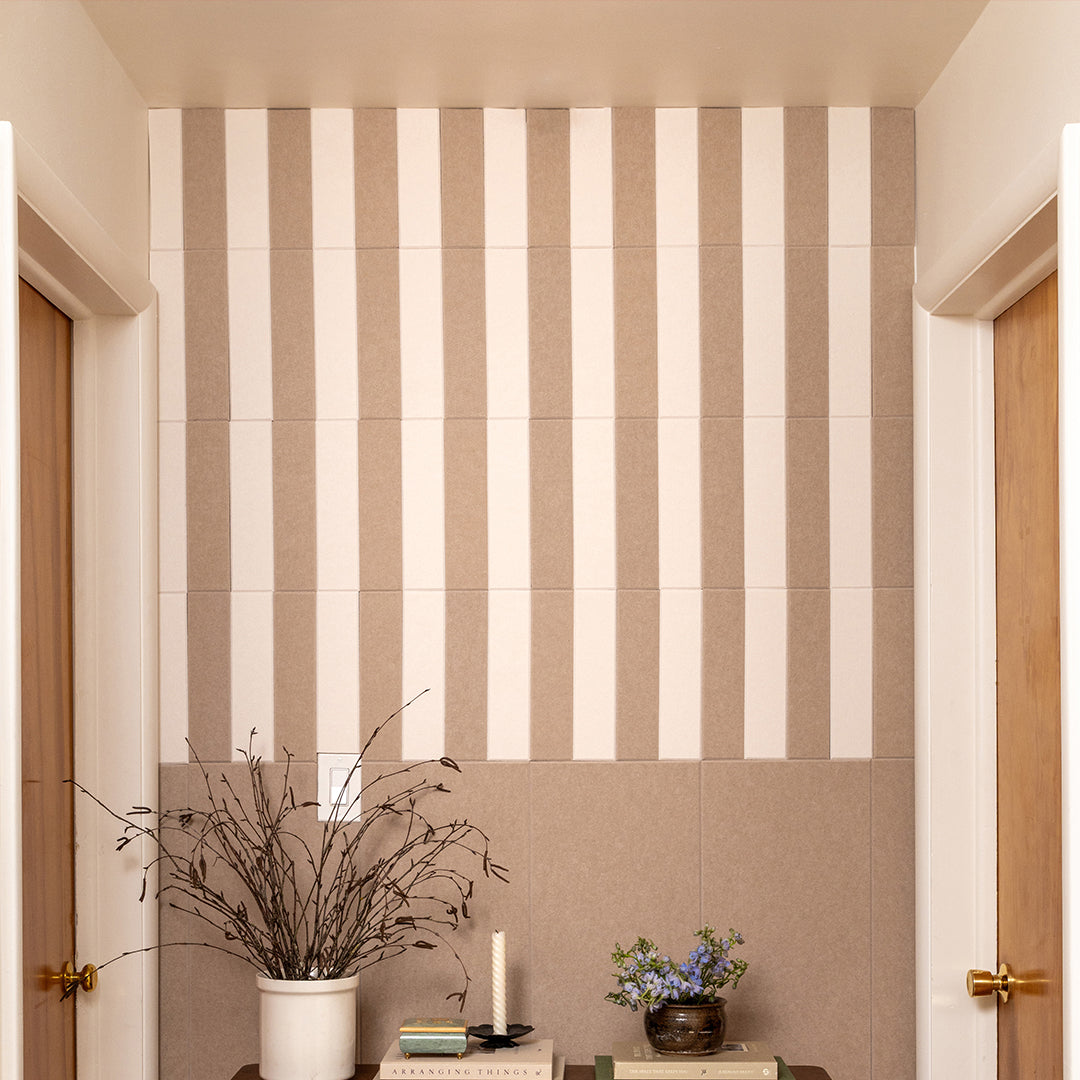 Beige and white striped wall with decorative elements like a plant and books.
