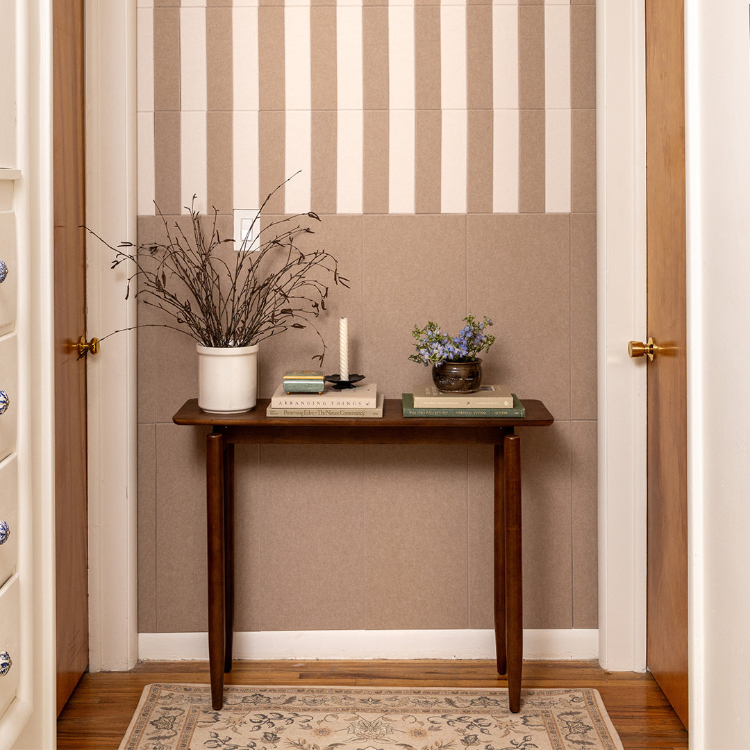 Wooden table with decorative items against a striped wall