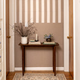 Wooden table with decorative items against a striped wall