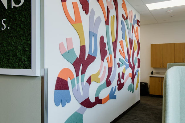 Colorful abstract mural by Elizabeth Olwen on a white wall with cabinets in the background