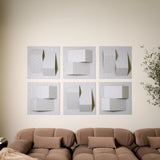 Grey acoustic felt wall tiles arranged in a modern 3D design  above a sofa
