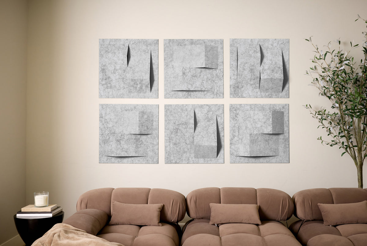 Brown sofa in a living room with abstract wall art and a plant.