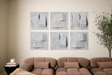 Brown sofa in a living room with abstract wall art and a plant.