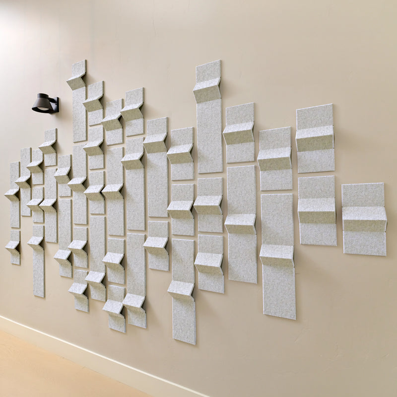 Grey acoustic felt tiles with peak points along a hallway with a light
