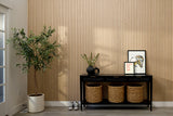 Entryway with decorative items including a plant, baskets, and a small table against a wooden paneled wall.