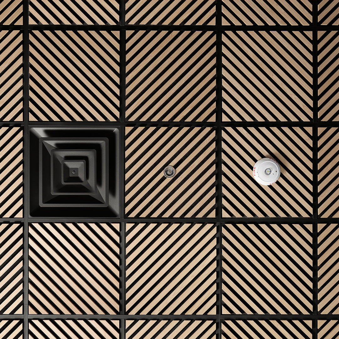 Black and beige geometric patterned tiles with a central black square and two silver circular objects.