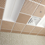 A ceiling grid with square acoustic panels featuring diagonal wood-look slats, white trim, and a central square vent or diffuser, installed above a patterned beige wall.