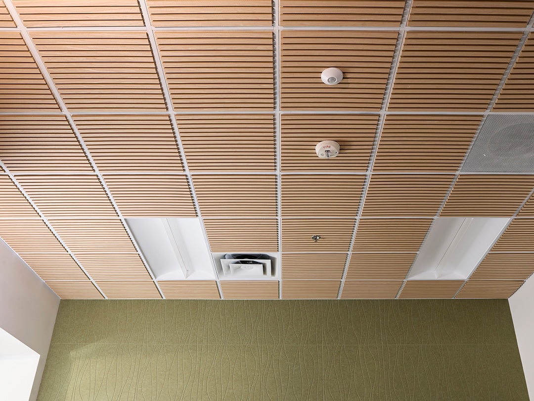 Wood slat ceiling panels in a large room with green accent wall.