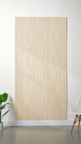 Beige Felt Right 4’ x 8’ PET felt panel with staggered lines engraved into the material against a white wall. A plant and chair are in the foreground.