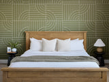 Bedroom with wooden bed, white bedding, and patterned green wall.