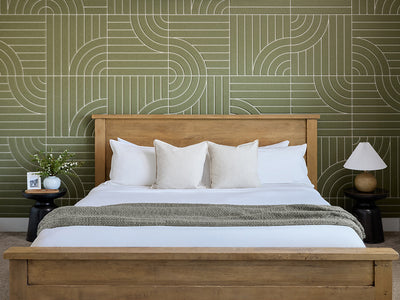 Bedroom with wooden bed, white bedding, and patterned green wall.