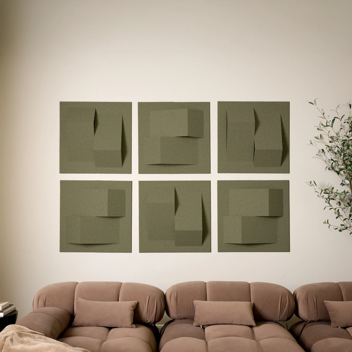 Green sound absorbing felt wall tiles in a geometric pattern above a living room sofa
