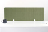 Green grid-patterned desk divider with white mounting brackets displayed on white desk surface.