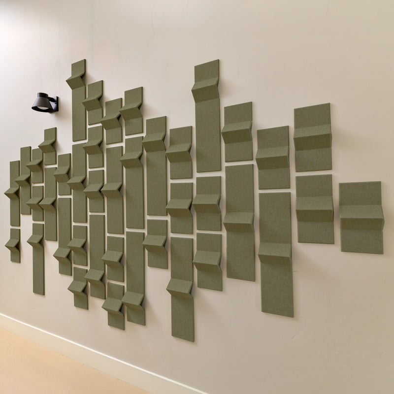 Green felt acoustic tiles on a wall with points of dimension