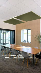 Two olive green square acoustic panels suspended from ceiling above conference table in office setting.