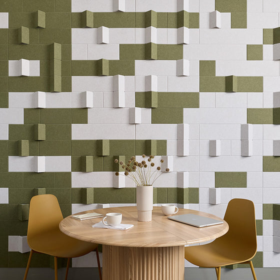 Two chairs and a table in a coffee shop with green and white wall art.