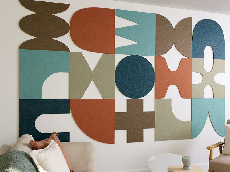 Geometric wall art panels in various colors on a white wall.