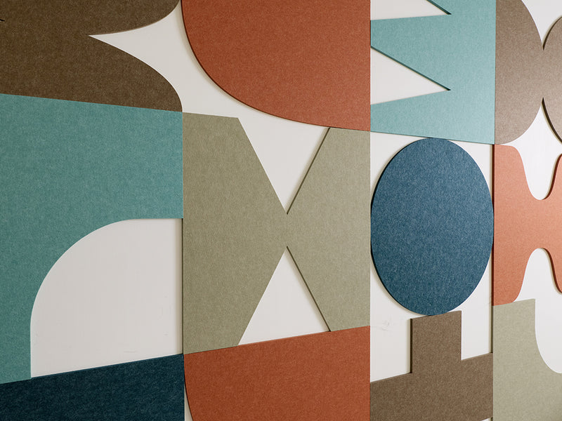 Colorful geometric acoustic wall tiles arranged in a pattern