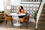 A Felt Right wall art design in a grey diamonds creating origami pattern on a white wall in a dining room with a small kitchen table and three chairs.