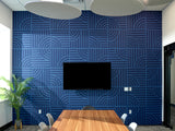 Blue geometric patterned wall tiles with circular and linear designs in office meeting room.