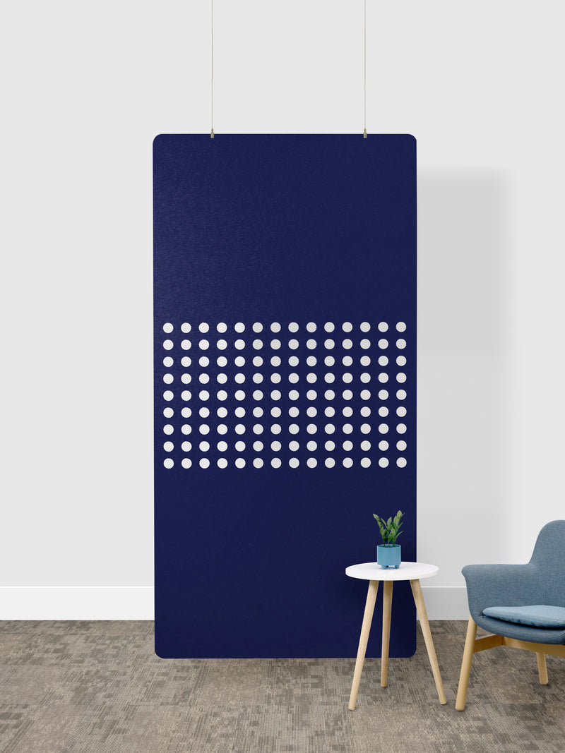Navy blue room divider with white dot pattern in a minimalistic room.
