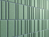 Layered rectangular tiles in varying widths of sage green with indigo grout lines creating an offset pattern.