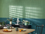 Green textured accent wall with kitchen table and chairs.