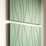 Two rectangular acoustic wall art panels in a muted sage green color, each decorated with thin engraved wavy vertical lines, displayed against a light neutral wall.