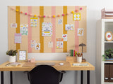 Peach, gold, and cream pinstriped cork bulletin board with various papers and decorations pinned to it.