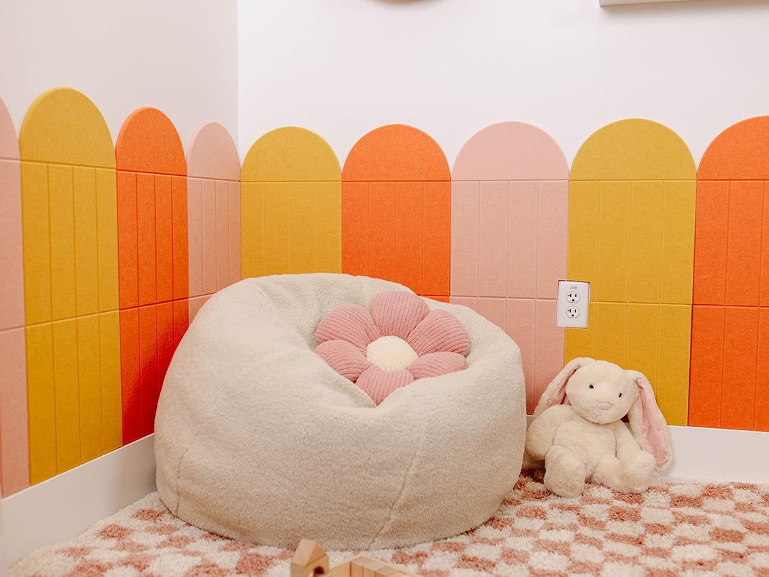 Children's room with a bean bag, plush toys, and colorful wall panels.