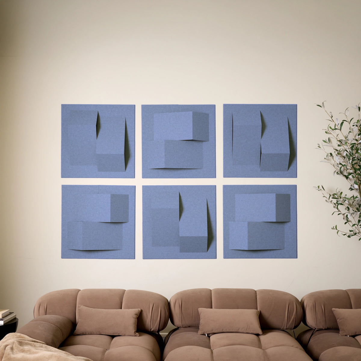 Purple-blue acoustic felt wall tiles arranged in a 3D design above a sofa