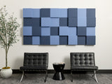 Blue and navy 3D acoustic wall panels arranged in checkerboard pattern above two black chairs.