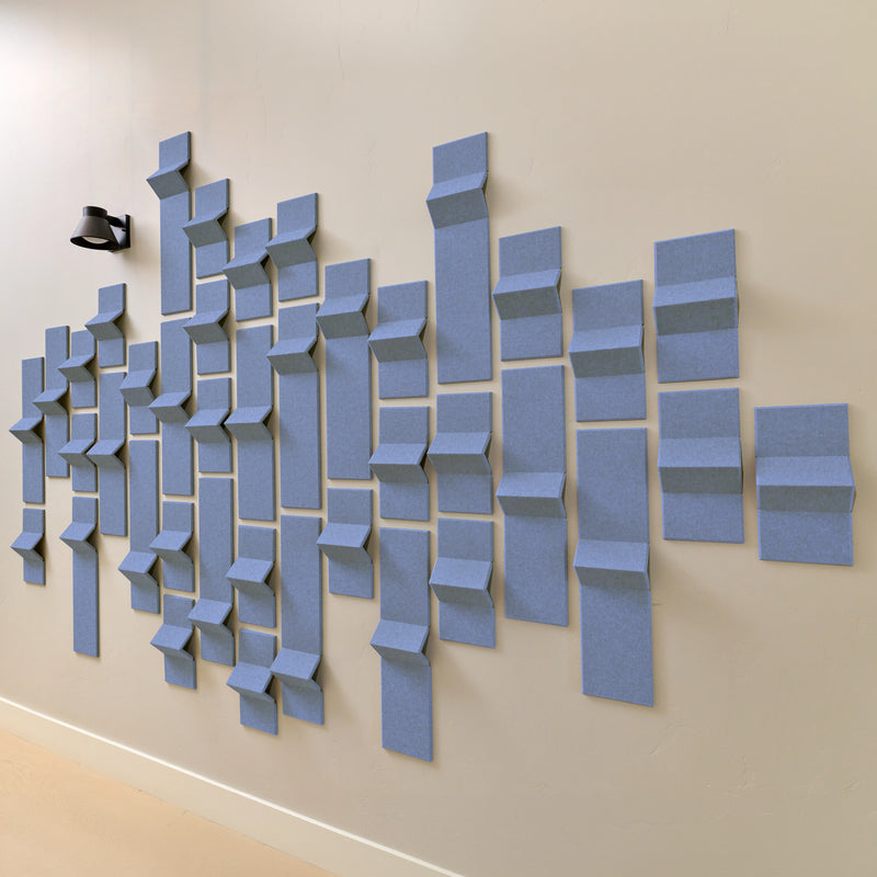 Soft blue with a hint of purple felt acoustic tiles with peak dimensions along a white wall